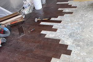 Installer measuring living room in Plano, TX for new flooring